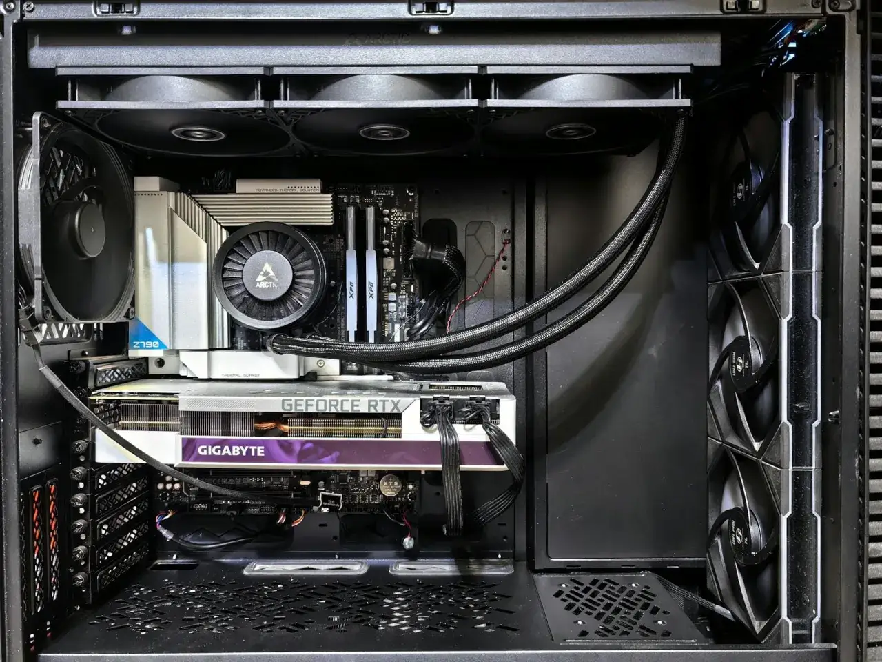 Wnętrze komputera z kartą graficzną Gigabyte GeForce RTX, chłodzeniem Arctic i pamięcią RAM XPG. Idealne do sprawdzenia podzespoł&oacute;w komputera.