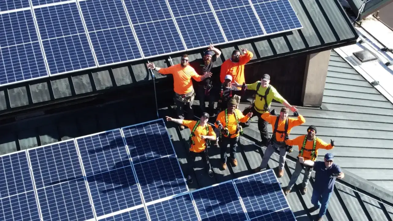 Ekipa montująca panele słoneczne na dachu, zadowoleni z pracy. **Columbus Energy opinie** potwierdzają ich profesjonalizm.