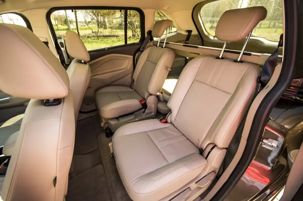 Wnętrze Ford C-Max Grand z jasnymi, skórzanymi siedzeniami, gotowe na rodzinne podróże.