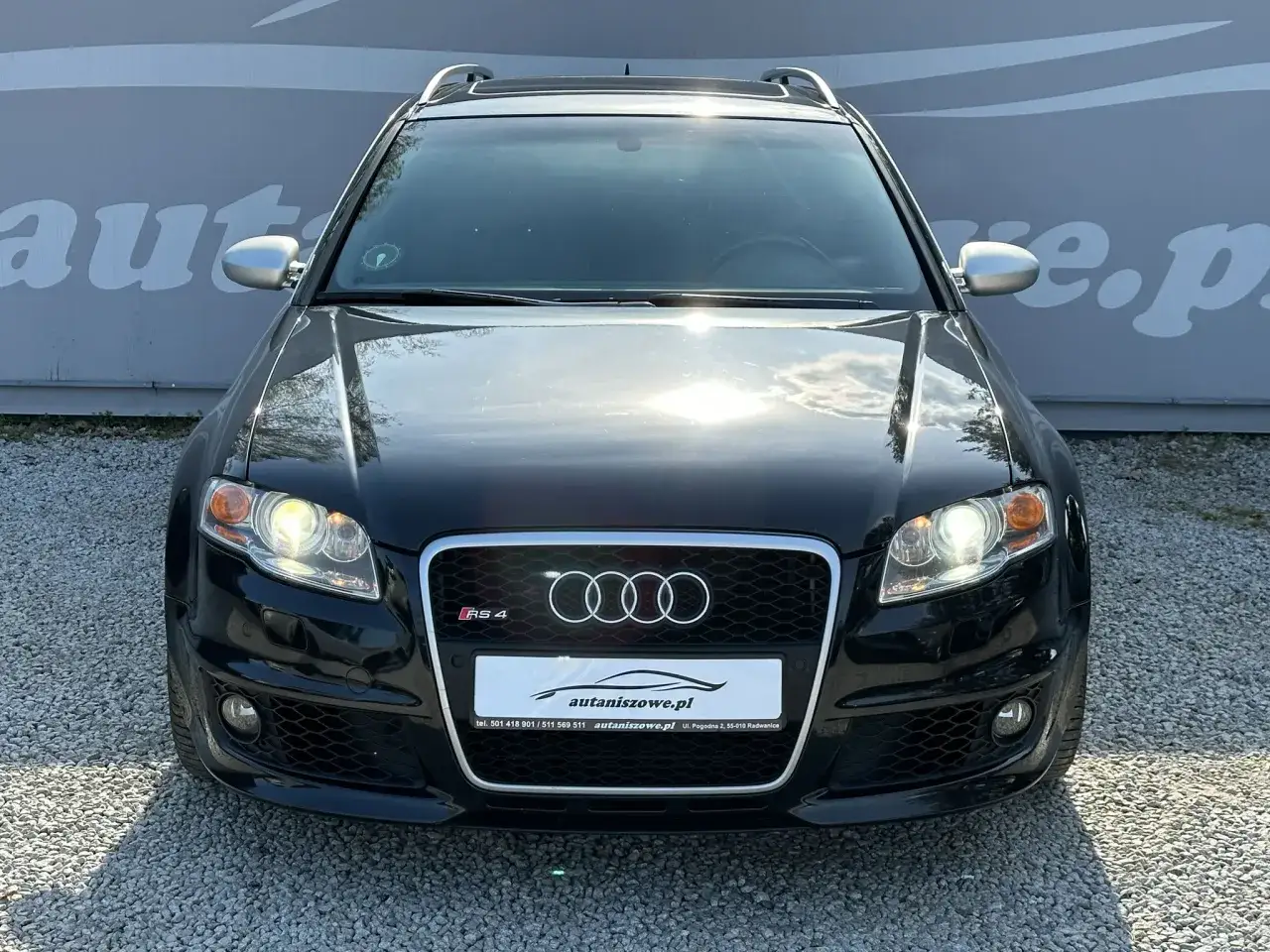 Czarny Audi RS4 B7 Avant z 2007 roku, z charakterystycznym grillem i reflektorami, zaparkowany na żwirze.