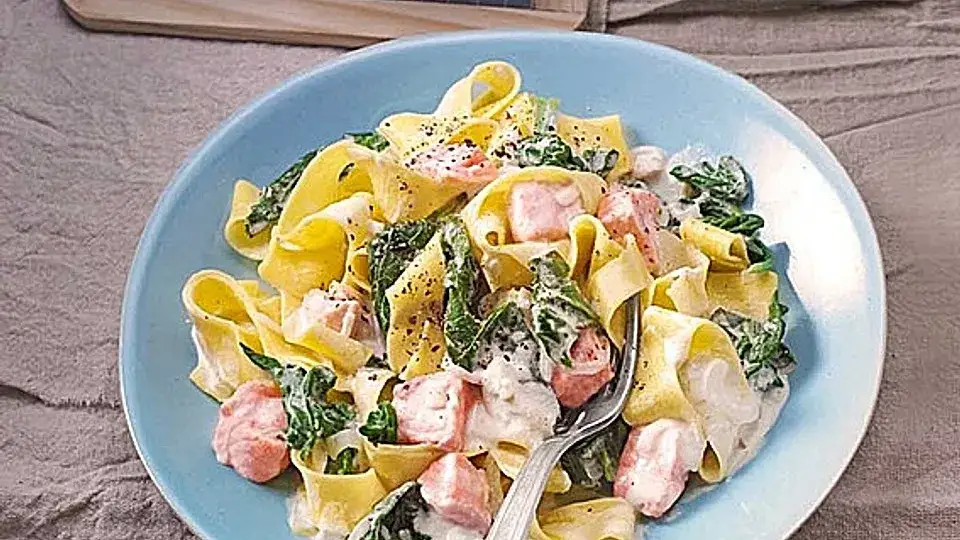 Nudeln mit Lachs Spinat und Kirschtomaten in einer Pfanne