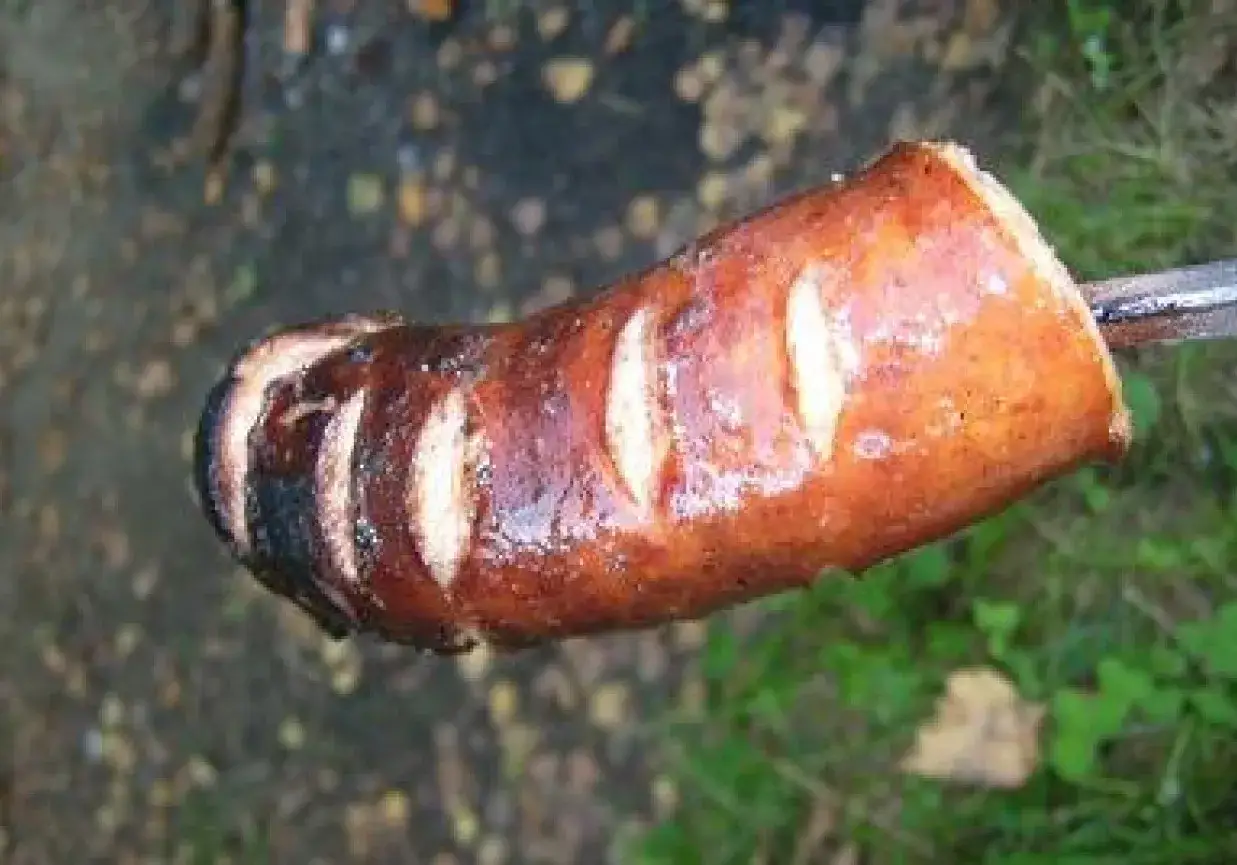 Apetyczna kiełbasa na ognisko, rumiana i nacięta, gotowa do jedzenia.