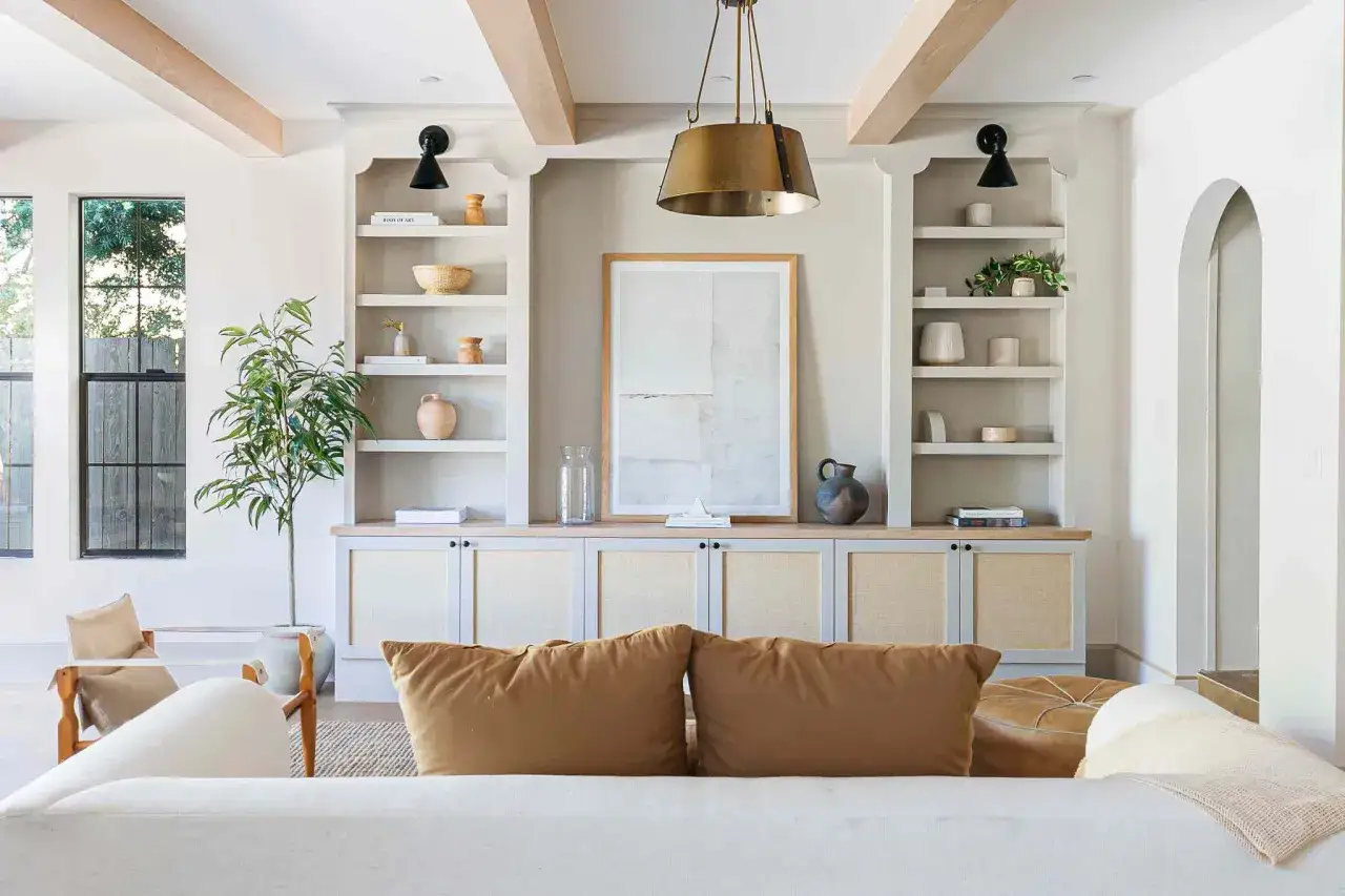 Librerie in cartongesso moderne con decorazioni in rattan e vasi in ceramica, un quadro astratto e una pianta d'appartamento.