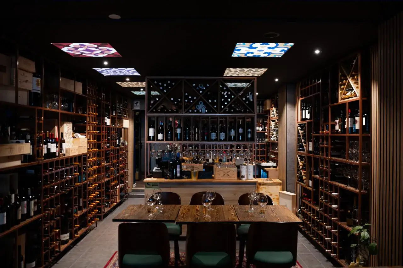 En vinbar med hyllor fyllda med flaskor, redo för en kväll med pasion tapas och goda viner.