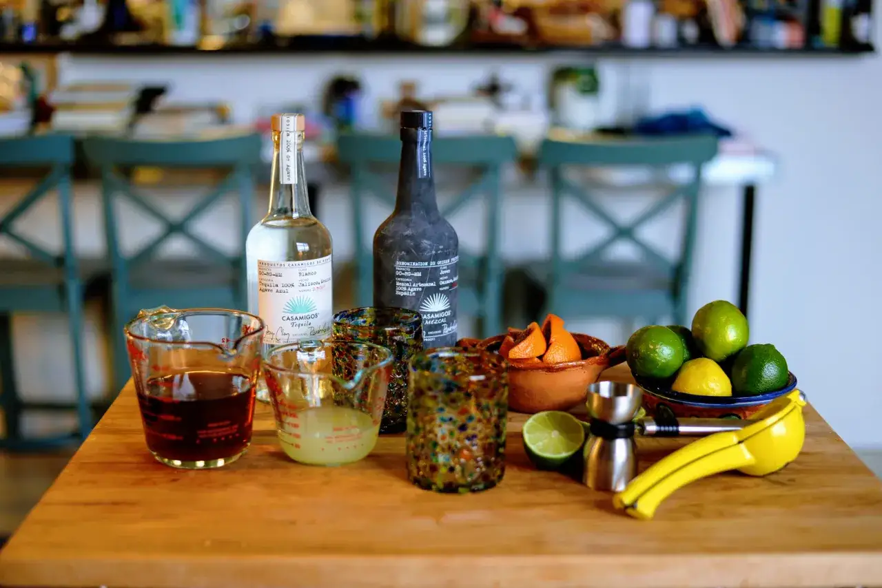 Składniki do margarity: butelki tequili i mezcalu, limonki, cytryny, pomarańcze, kieliszki i miarki. Różnica między mezcalem a tequilą w klasycznej margaricie.