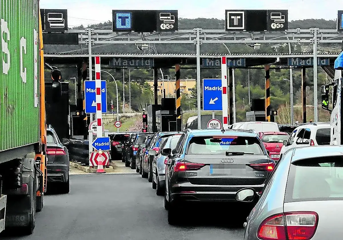 Tráfico en peaje de Madrid a Salamanca. Coches en fila para pagar. Señales indican Madrid y dirección.