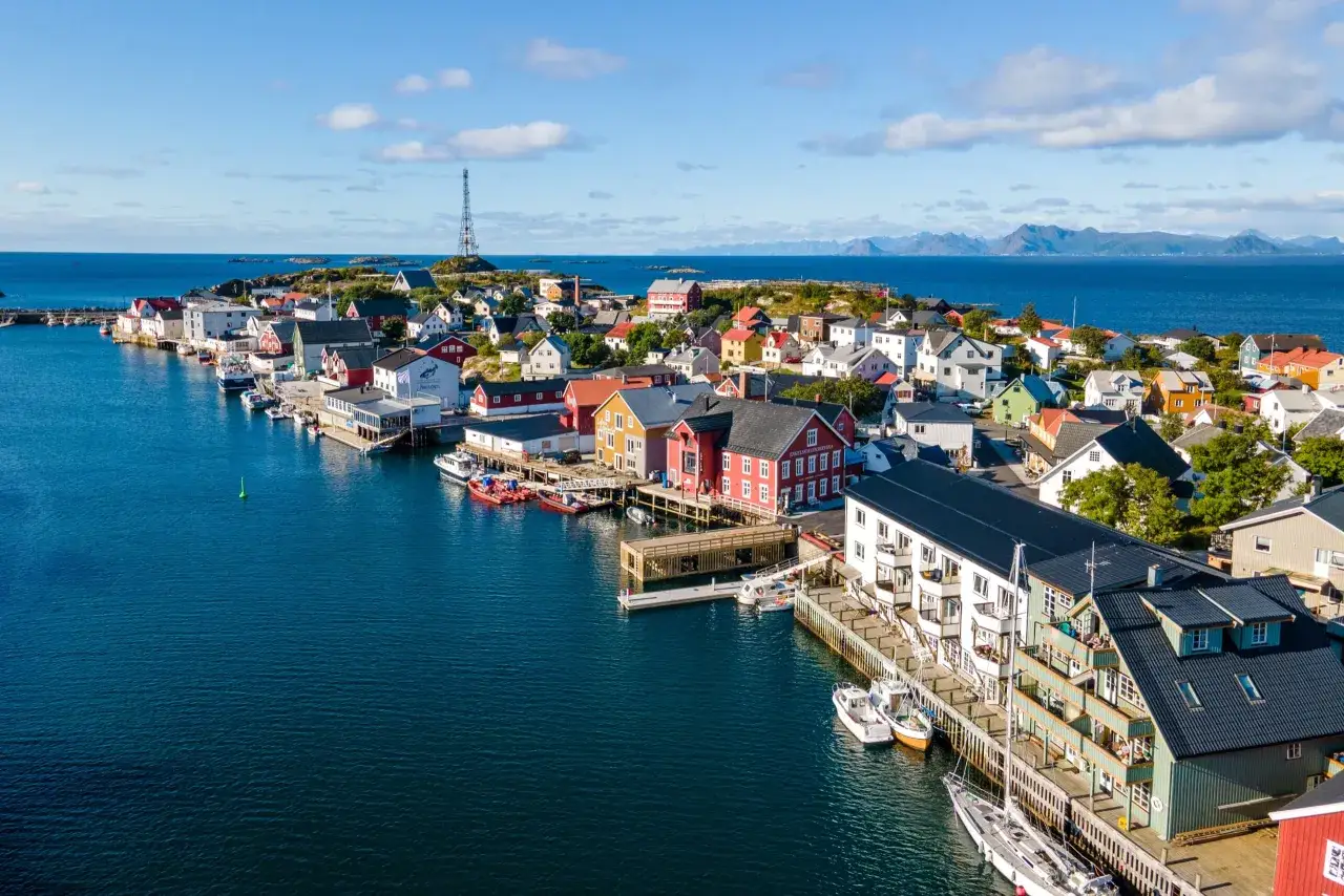 Vue aérienne d'un village de pêcheurs coloré sur pilotis, avec des bateaux amarrés dans le port. Un aperçu des plus beaux endroits des îles Lofoten.