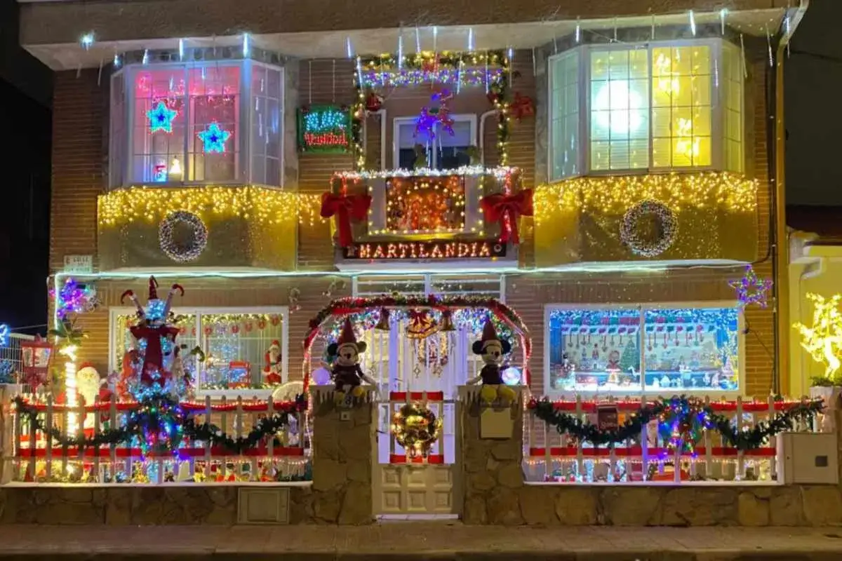 Casa decorada con luces navideñas, creando un **parque mágicas navidades**. Figuras de Mickey Mouse, árboles y guirnaldas iluminan la fachada.