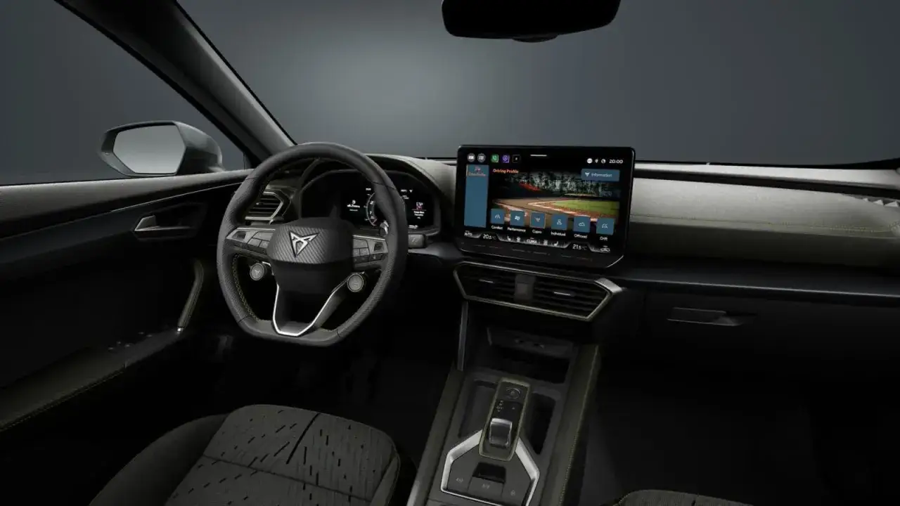 Wnętrze Formentor Cupra z ekranem multimediów wyświetlającym tor wyścigowy.