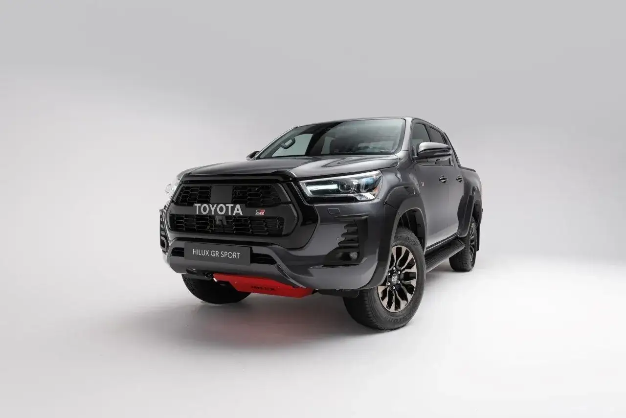 Mroczny, sportowy Toyota Hilux GR Sport z czerwonym elementem pod zderzakiem, gotowy na każdą przygodę.