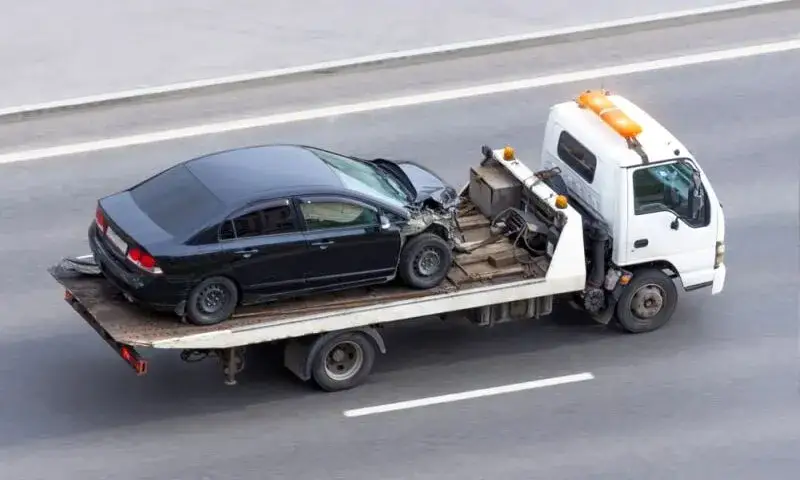 laweta z samochodem na autostradzie