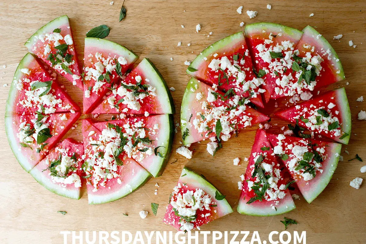 Wassermelonenstücke, belegt mit zerbröseltem Feta und Minze, sehen aus wie eine erfrischende Pizza. Ein ungewöhnlicher, aber köstlicher pizza belag.