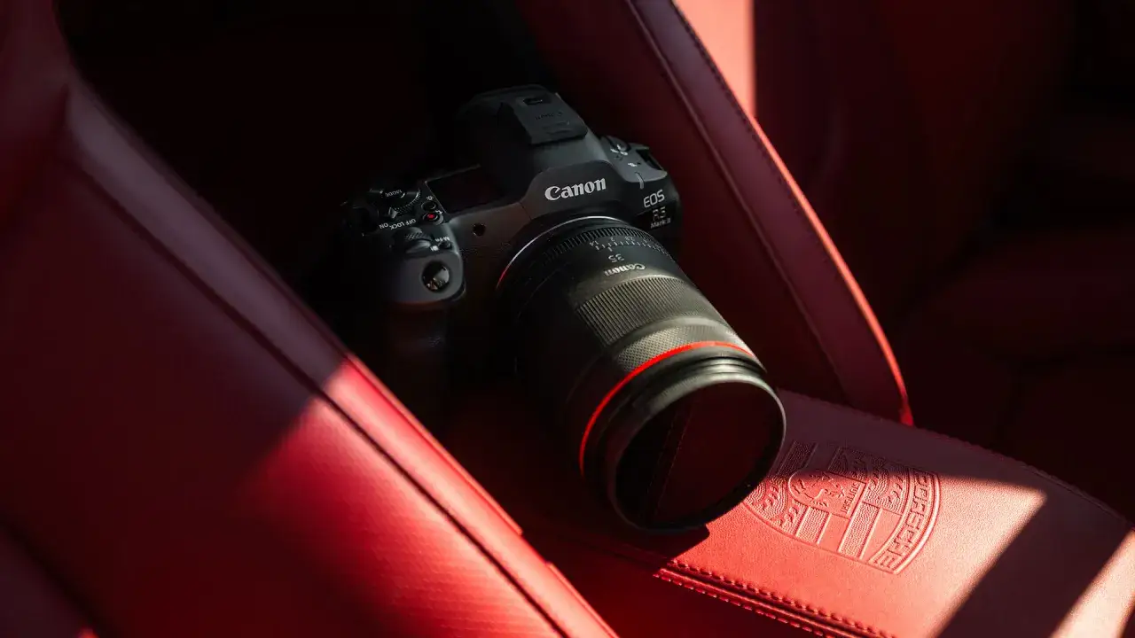 Canon R5 z obiektywem 35mm leży na czerwonej skórzanej kanapie Porsche.