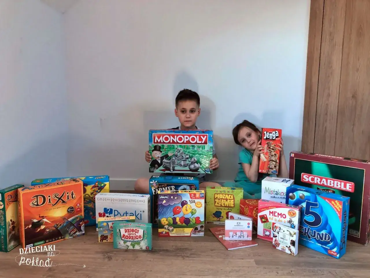 Dzieci z dumą prezentują swoje gry planszowe, w tym Monopoly i Jengę. To idealny zestaw na rodzinne popołudnie, gdzie gra 7+ zapewni mnóstwo śmiechu.