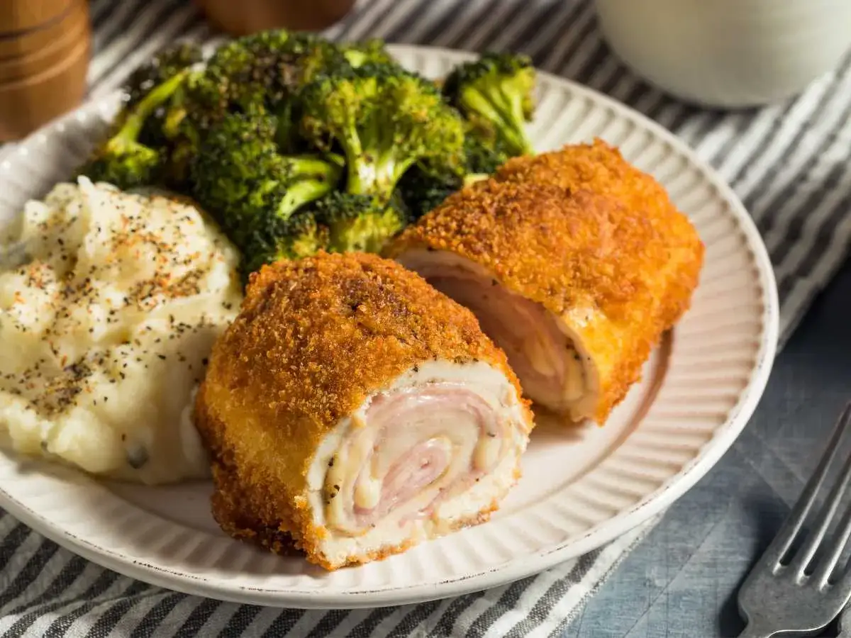 Un delicioso cordon bleu, crujiente por fuera y jugoso por dentro, acompa&ntilde;ado de pur&eacute; de patatas y br&oacute;coli.
