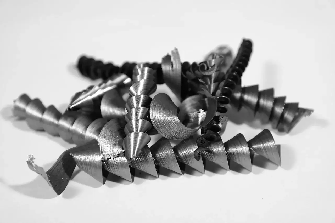 Wióry po frezowaniu aluminium, spiralne i ostre, świadczą o precyzyjnej obróbce metalu.