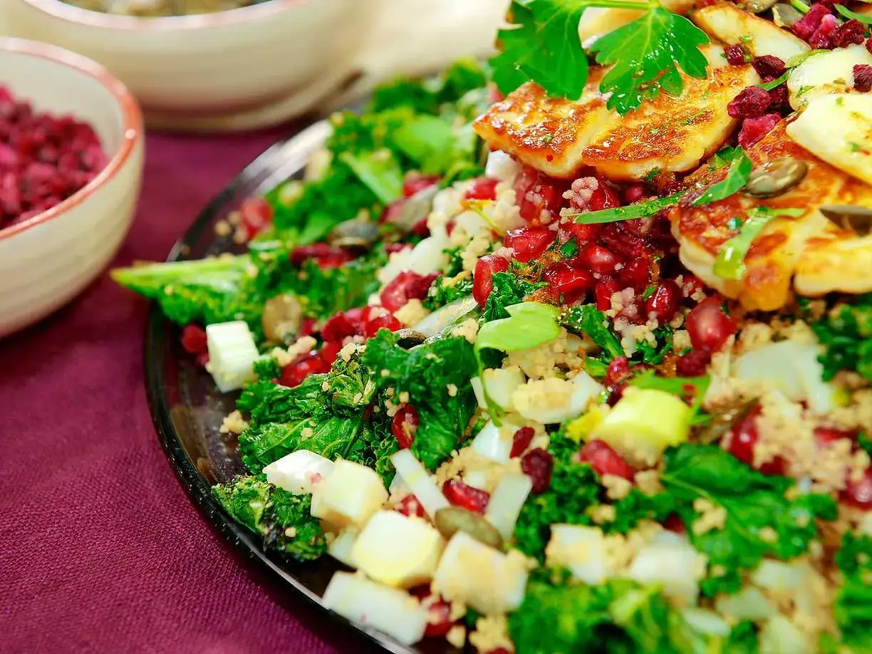 En härlig couscous sallad med halloumi, granatäpple och gröna blad. En färgsprakande och smakrik rätt.