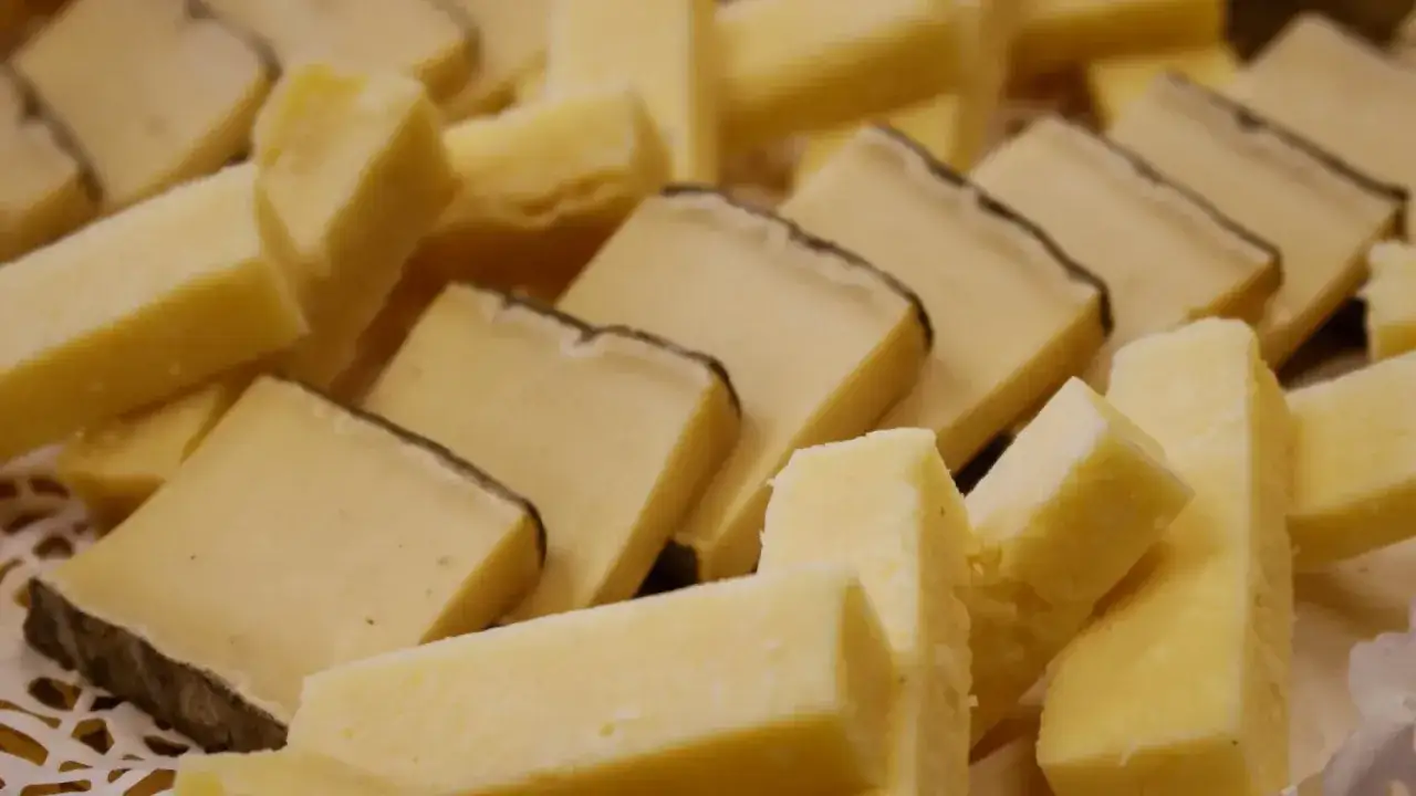 Un assortiment de fromages coup&eacute;s en d&eacute;s et en b&acirc;tonnets, &eacute;voquant les sp&eacute;cialit&eacute;s d'Auvergne.