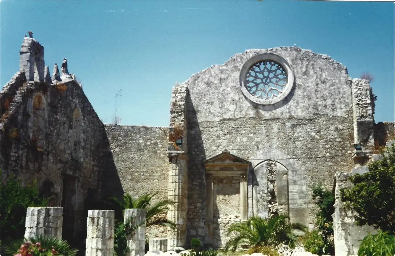 Ruinas de una iglesia siciliana con un roset&oacute;n y palmeras. Lo mejor de Sicilia, un vestigio hist&oacute;rico.