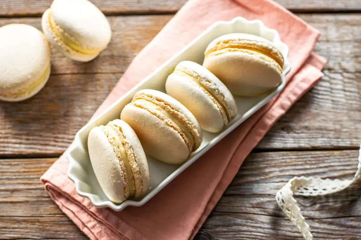 Macarons bianchi con ripieno cremoso, pronti per essere gustati. La ganache per macarons &egrave; il cuore di questi dolcetti perfetti.