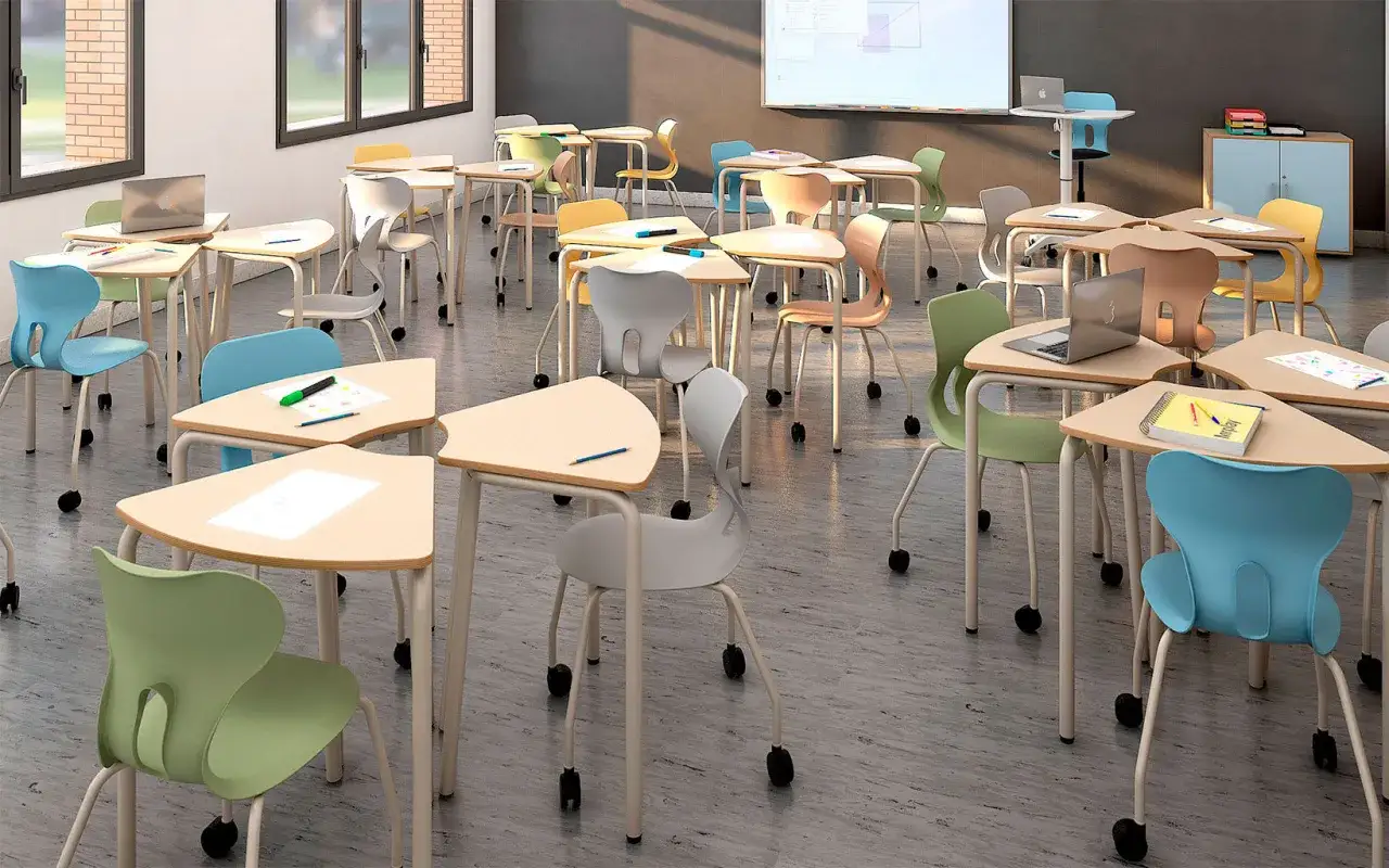 Aula moderna con mobiliario escolar innovador: mesas triangulares y sillas ergonómicas de colores vibrantes, listas para el aprendizaje.