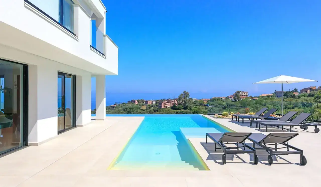 Magnifique g&icirc;te en Sicile avec piscine &agrave; d&eacute;bordement, chaises longues et vue sur la mer.