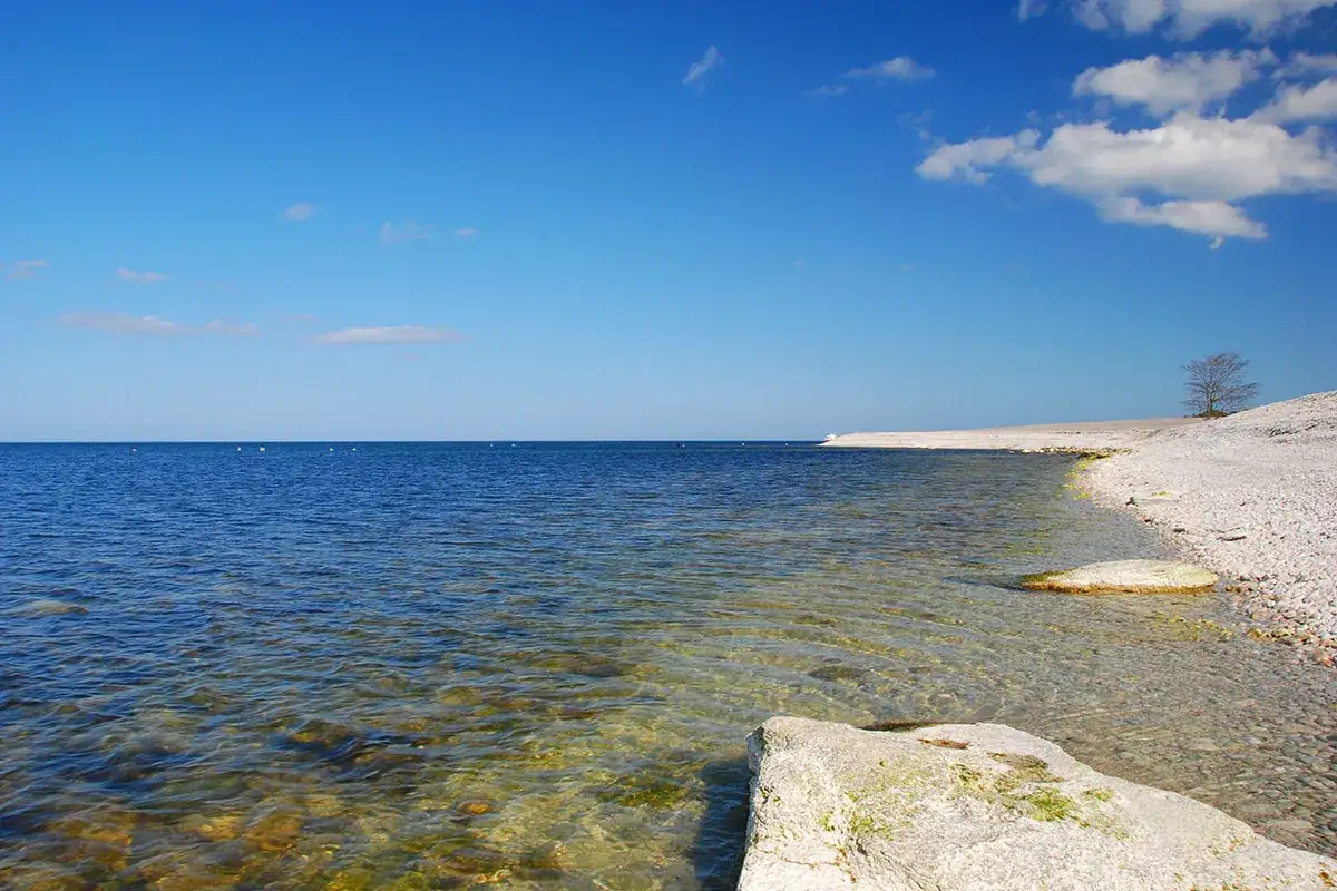 Spokojne morze i kamienista plaża. Szwecja ma tysiące wysp, a ta sceneria mogłaby być jedną z nich.