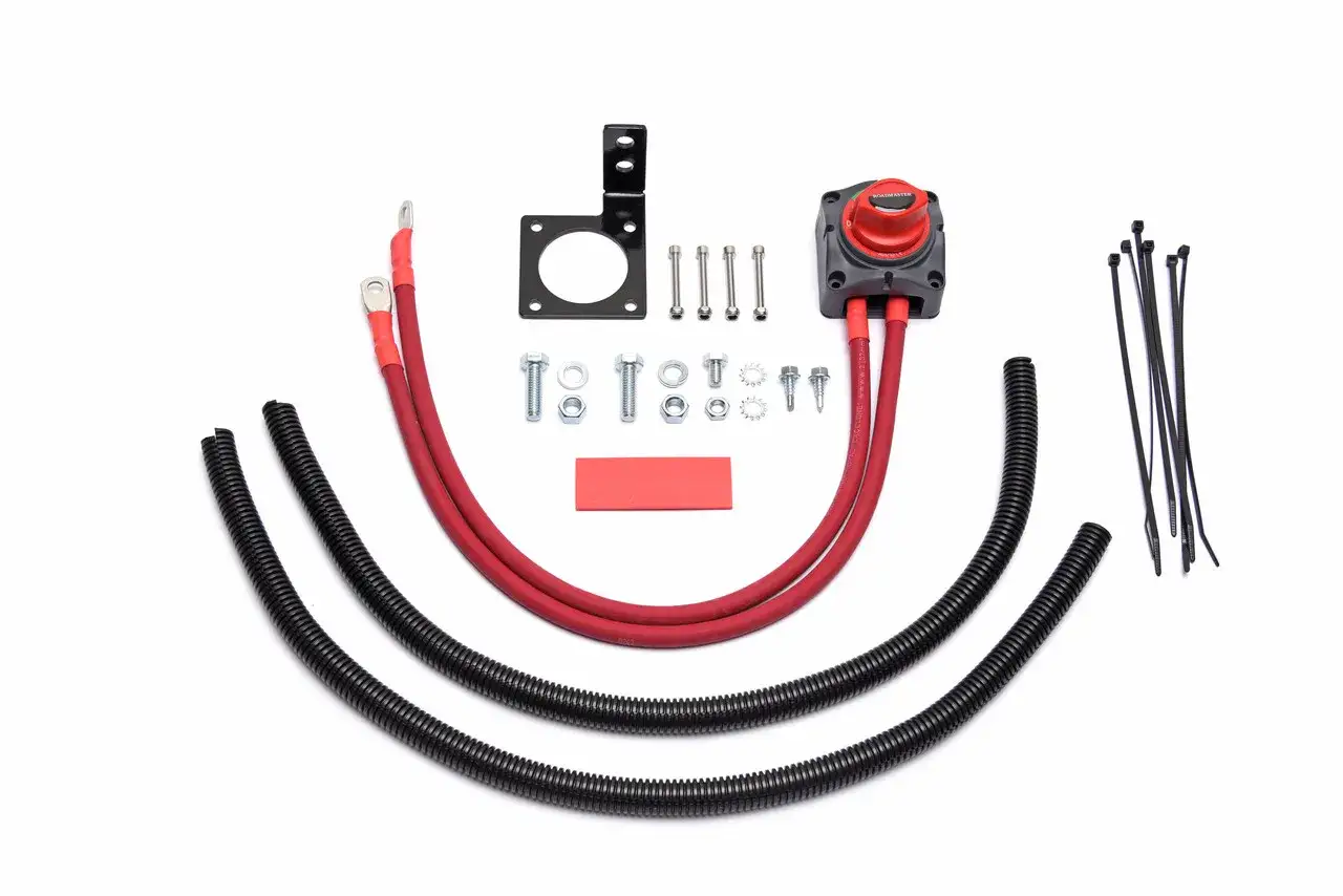 Werkzeugset für das sichere **batterie abklemmen**: Hauptschalter, rote Kabel, schwarze Schutzschläuche, Schrauben und Kabelbinder.