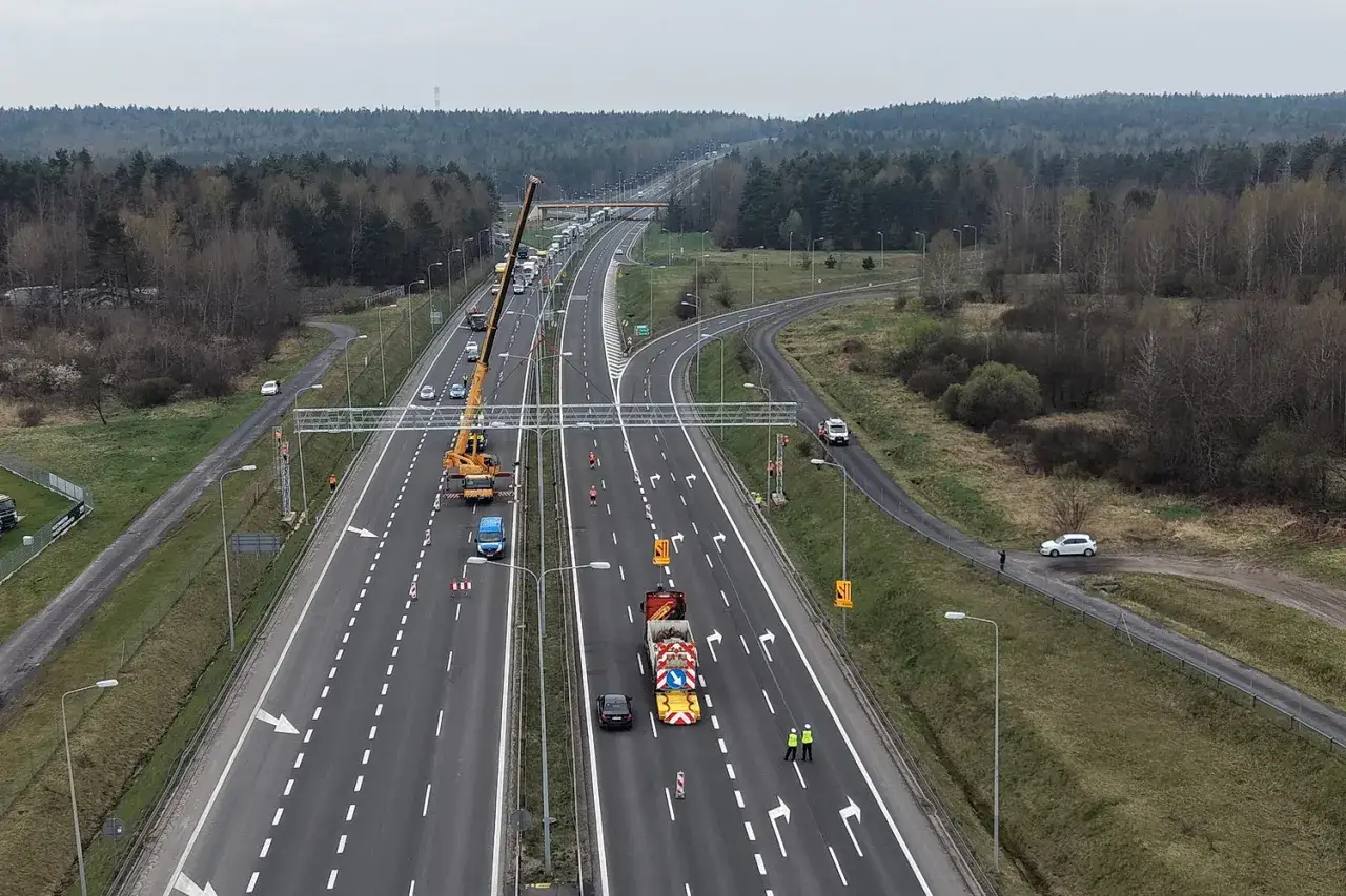 Na S7 trwa montaż odcinkowego pomiaru prędkości. Widoczny dźwig, ciężarówki i pracownicy drogowi.