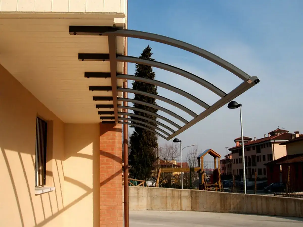 Montaggio pensilina policarbonato: struttura moderna ad arco protegge dall'esterno, con un design elegante e funzionale.
