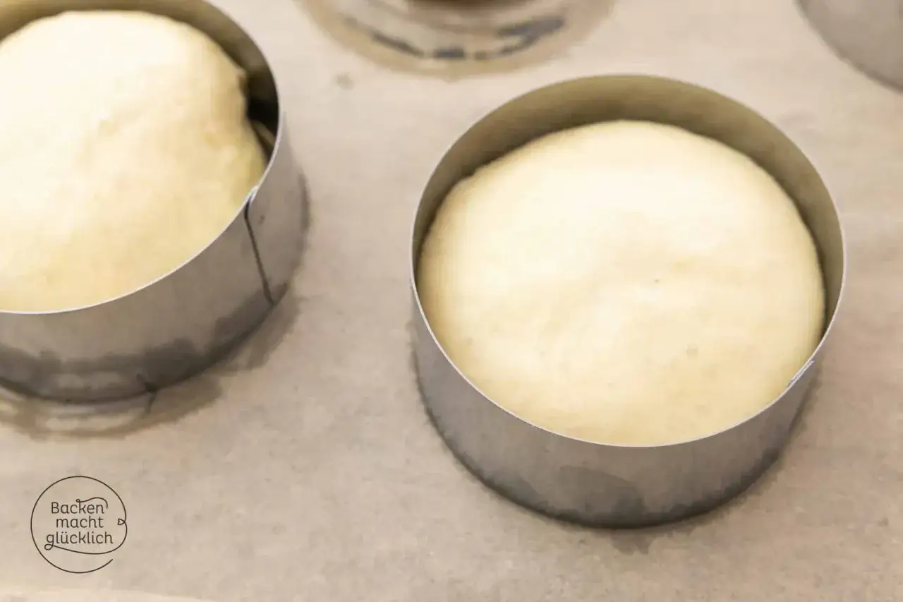Teiglinge f&uuml;r ein Burger Buns Rezept in Metallringen auf Backpapier.