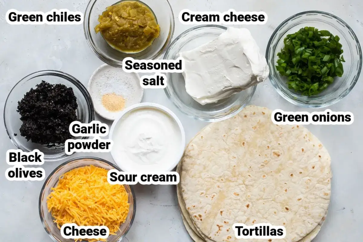Zutaten f&uuml;r Wraps Rezepte: gr&uuml;ne Chilis, schwarze Oliven, geriebener K&auml;se, Knoblauchpulver, Salz, saure Sahne, Frischk&auml;se, Fr&uuml;hlingszwiebeln und Tortillas.