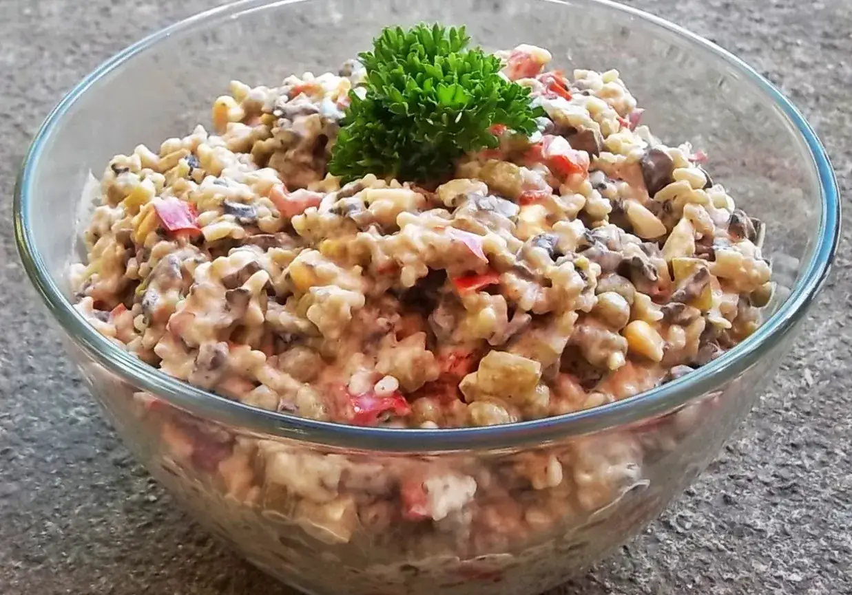 Pyszna sałatka z pieczarkami smażonymi, papryką i kukurydzą, udekorowana natką pietruszki.
