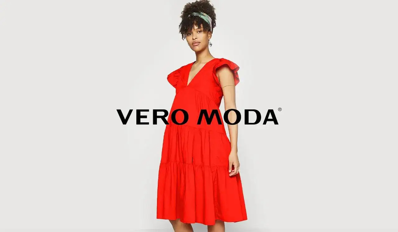 En kvinna i en r&ouml;d kl&auml;nning fr&aring;n Vero Moda outlet.