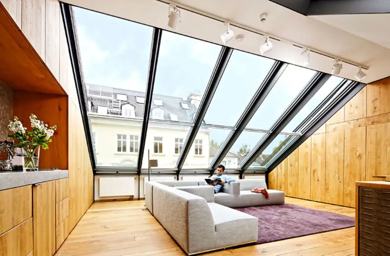 Moderne Dachgeschosswohnung mit gro&szlig;em Glasdach. Tolle haus umbauen ideen vorher-nachher: viel Licht, Holz und gem&uuml;tliche Sitzm&ouml;bel.