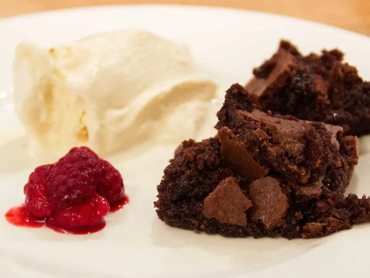 En bit seg kladdkaka med vaniljglass och hallon. En perfekt kombination f&ouml;r fikat.