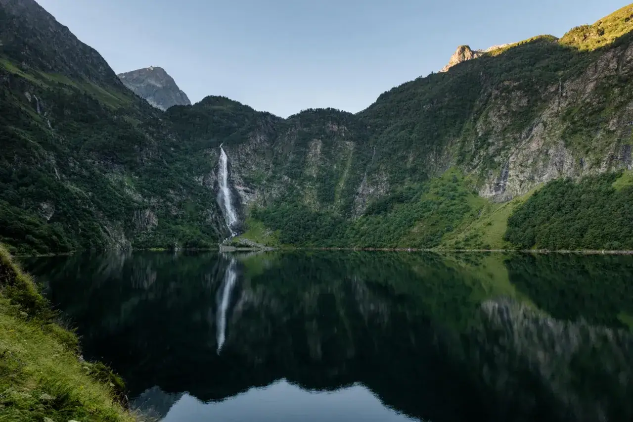 Le lac d'Oo, miroir des montagnes verdoyantes et de sa cascade majestueuse, offre un spectacle paisible.