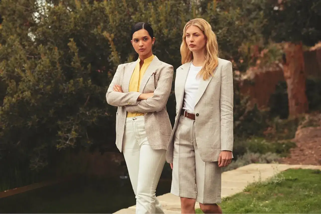 Dwie kobiety w eleganckich, lnianych marynarkach i spodniach prezentują styl casual dress code.