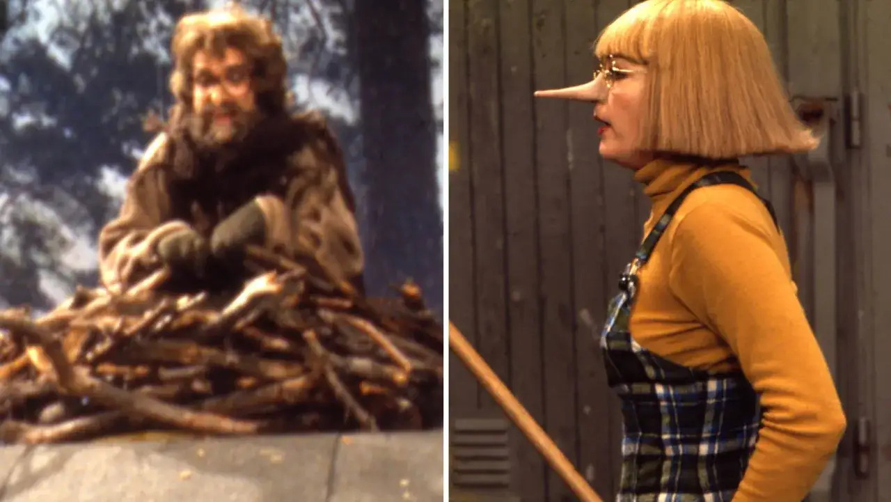 En man med skägg och glasögon sitter på en hög med ved. Bredvid honom en kvinna med lång näsa och randig hängselklänning, från ett gammalt barnprogram.