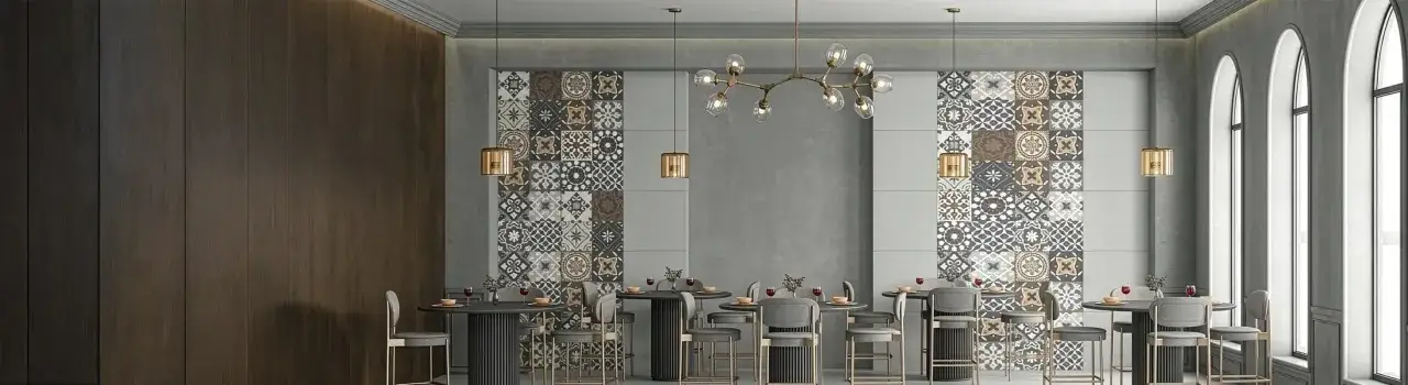 Un comedor moderno con paredes de madera oscura y una **cenefa que es** un mosaico de azulejos geométricos. Mesas altas y sillas de terciopelo gris completan el espacio.