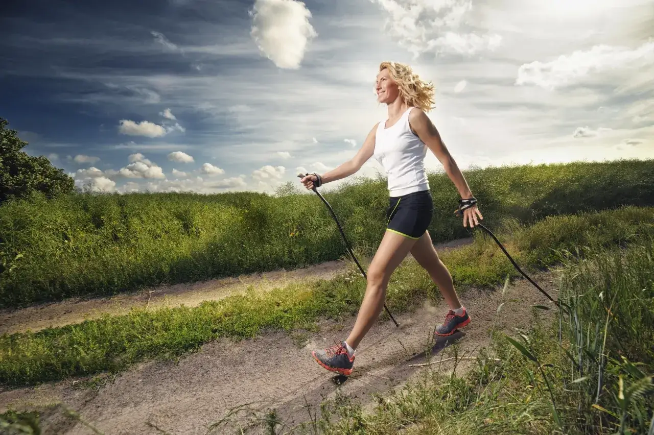 nordic walking w lesie, kobieta z kijkami