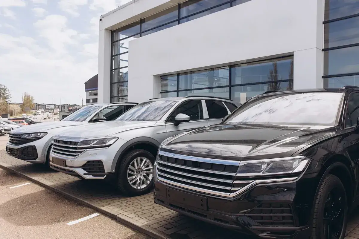 Nowe samochody na firmę, lśniące czarne i srebrne SUV-y czekają na odbiór.
