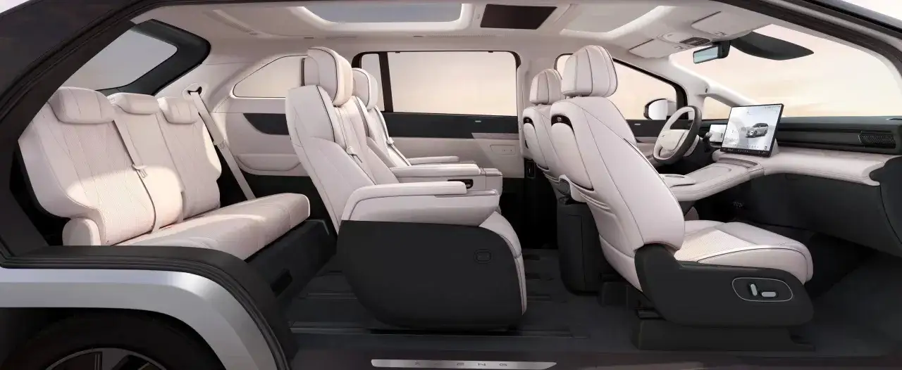 Intérieur spacieux du Xpeng X9, avec des sièges en cuir clair, un grand écran tactile et un toit panoramique.