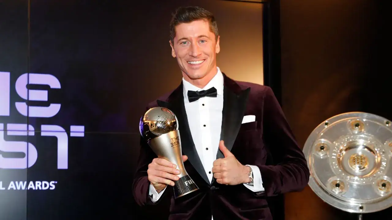 Robert Lewandowski, piłkarz roku FIFA, z dumą prezentuje swoje trofeum.