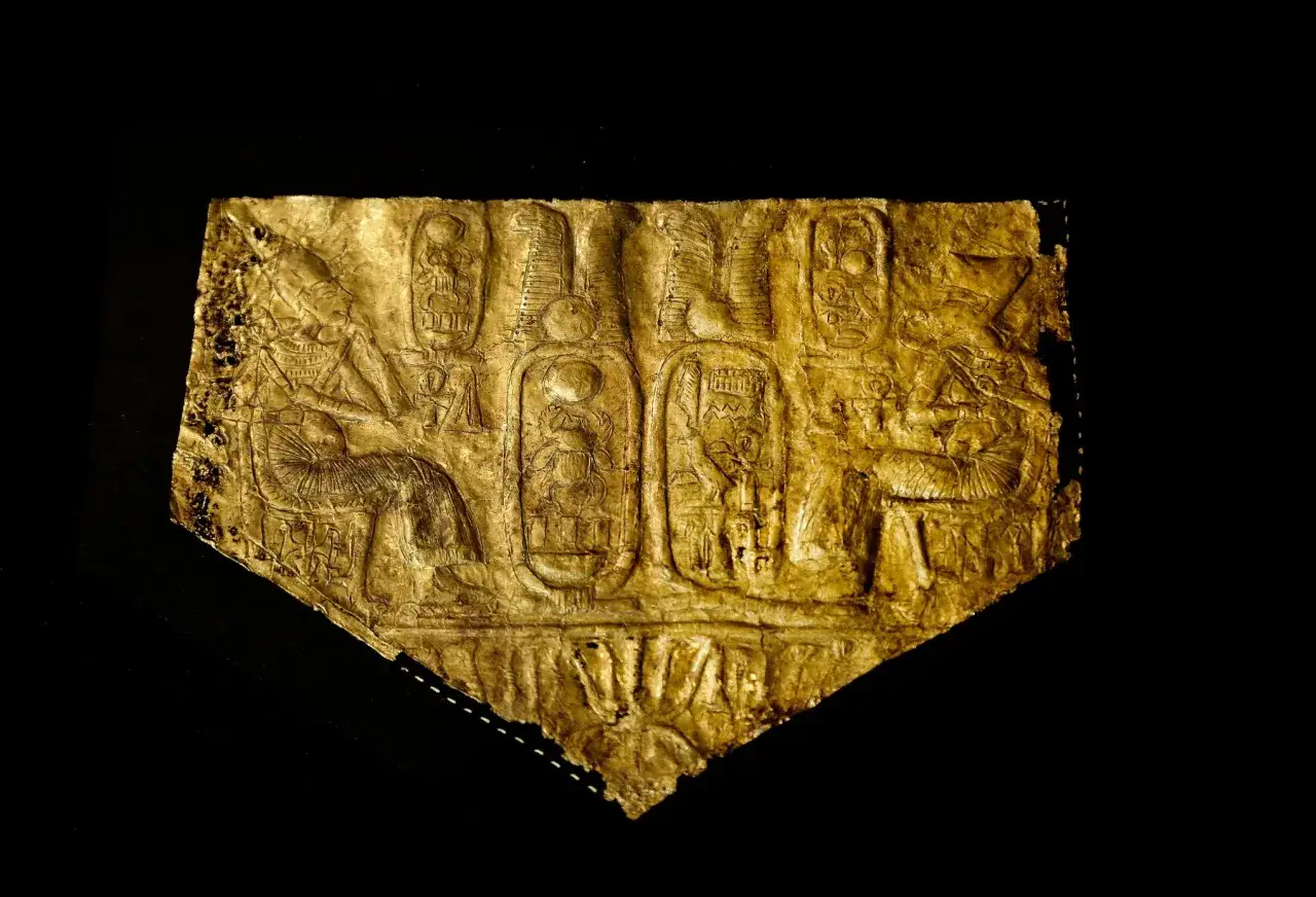 Goldene Plakette mit Hieroglyphen und Darstellungen, die an Pharao Tutanchamun erinnern.