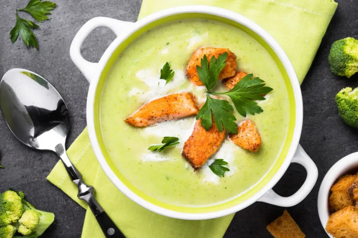 Brokkolisuppe in einer Sch&uuml;ssel mit verschiedenen Toppings wie Lachs und Cro&ucirc;tons