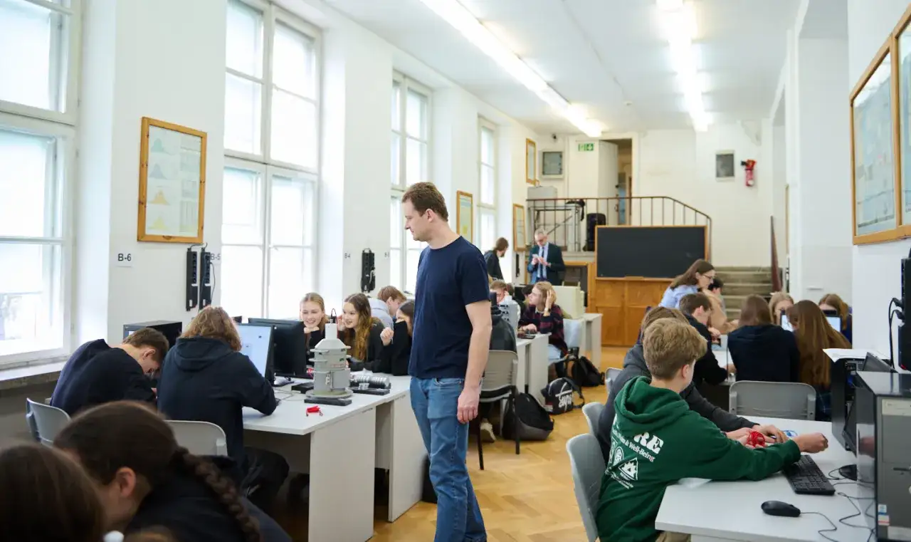 Studenci na studiach magisterskich zaocznych w Warszawie pracują przy komputerach w sali laboratoryjnej.