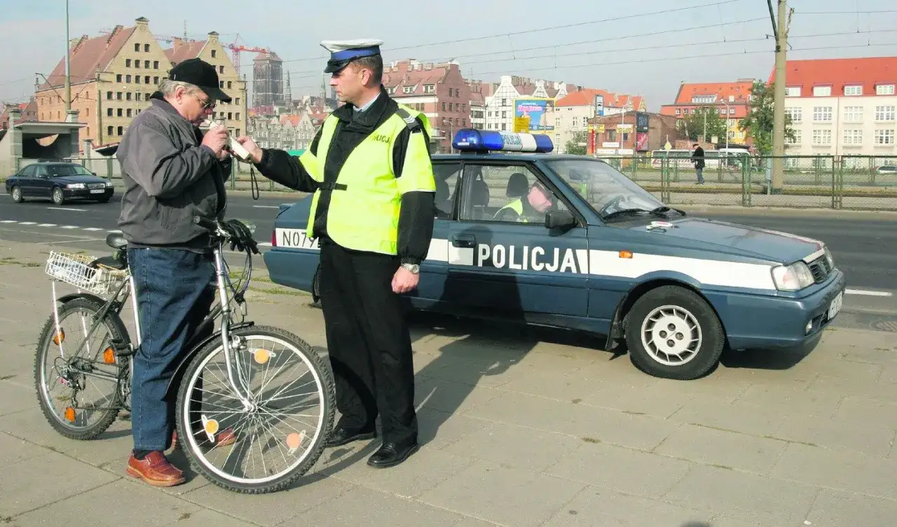 Policjant bada alkomatem rowerzystę. Czy jak jedziesz pijany rowerem to zabierają prawo jazdy?