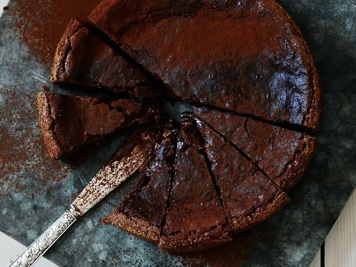 En saftig protein kladdkaka, pudrad med kakao, skuren i bitar med en vacker kniv. Perfekt för en fika!
