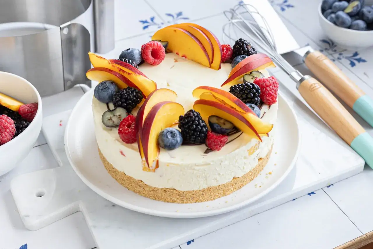 Delizioso cheesecake alla frutta con pesche, lamponi, mirtilli e more. Un tripudio di colori e sapori estivi.